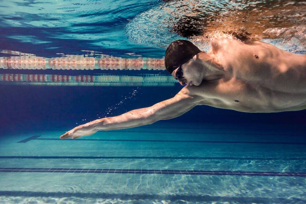 man swimming freestyle underwater